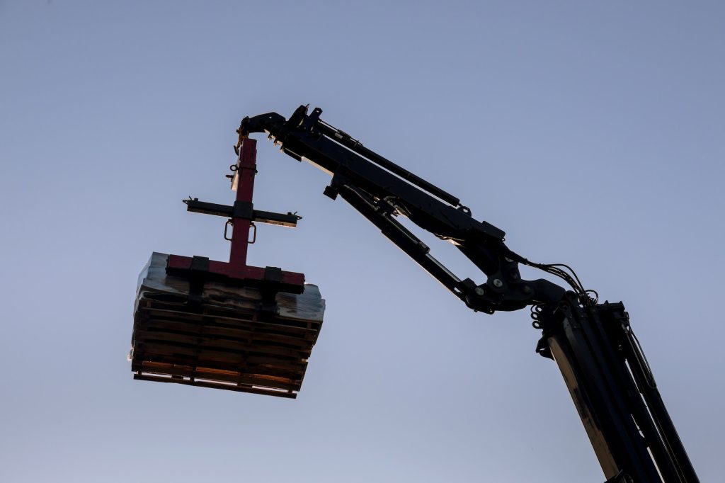 Cranes lifter building materials to the building with crane truck in the roof of the builders