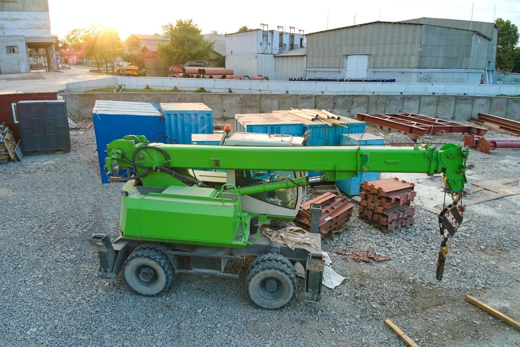 Lifting crane tractor on industrial construction site. Heavy duty machinery for building industry